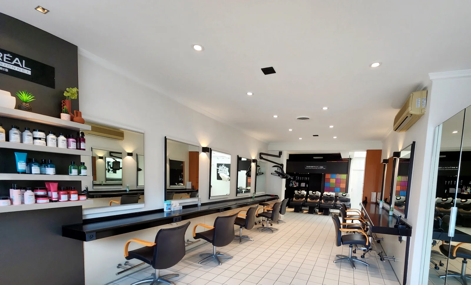 Intérieur du salon Studio Hair à Coudekerque-Branche, postes de coiffage et Color Bar au fond